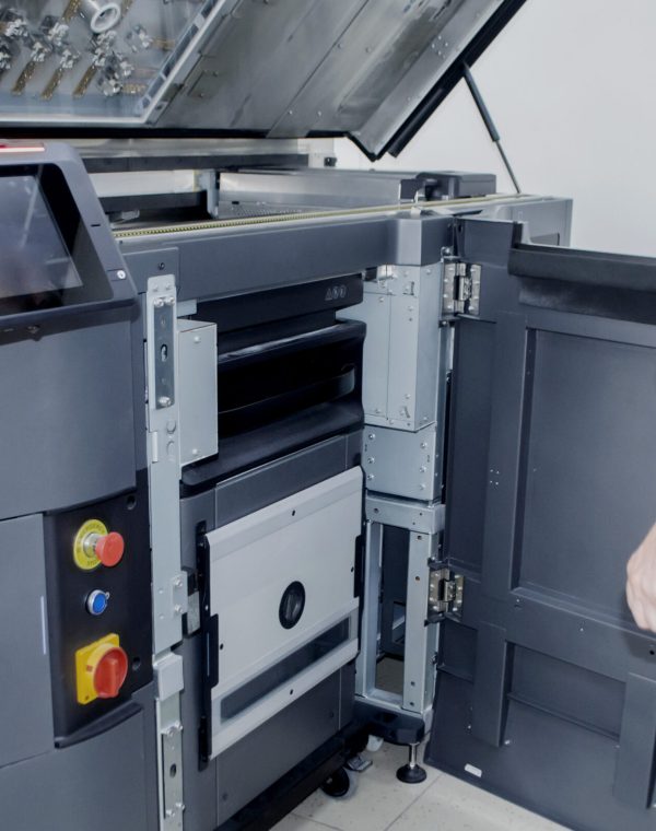 A man worker and a large industrial powder 3d printer in a laboratory in a factory. Multi Jet Fusion. Industrial equipment. New modern 3D printing , additive progressive technology. MJF